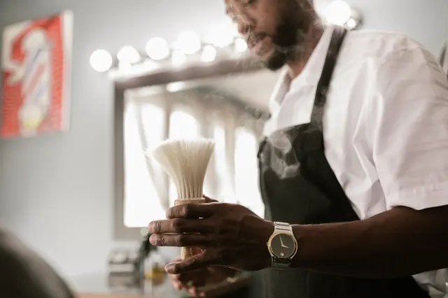 Barbier avec blaireau devant le miroir éclairé